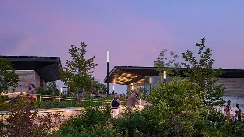 Twilight view of the Niagara Falls Visitor Center, featuring a sleek canopy and soffit made of Pure + FreeForm’s blackened steel finish, Frozen Titanium.